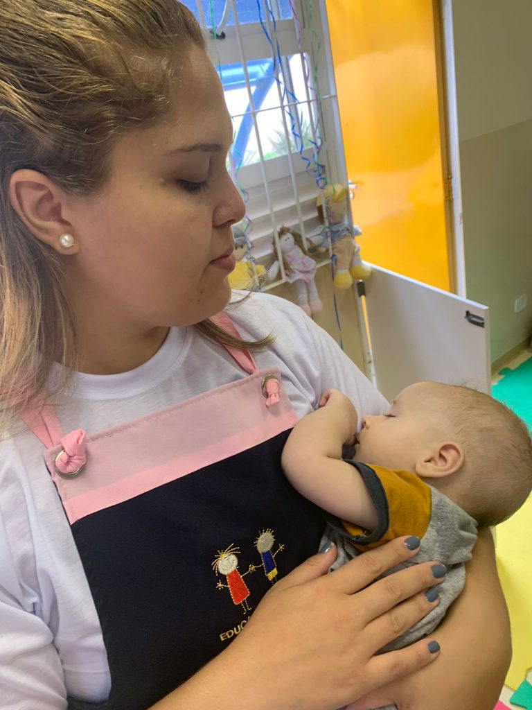 Professora com bebê no colo.