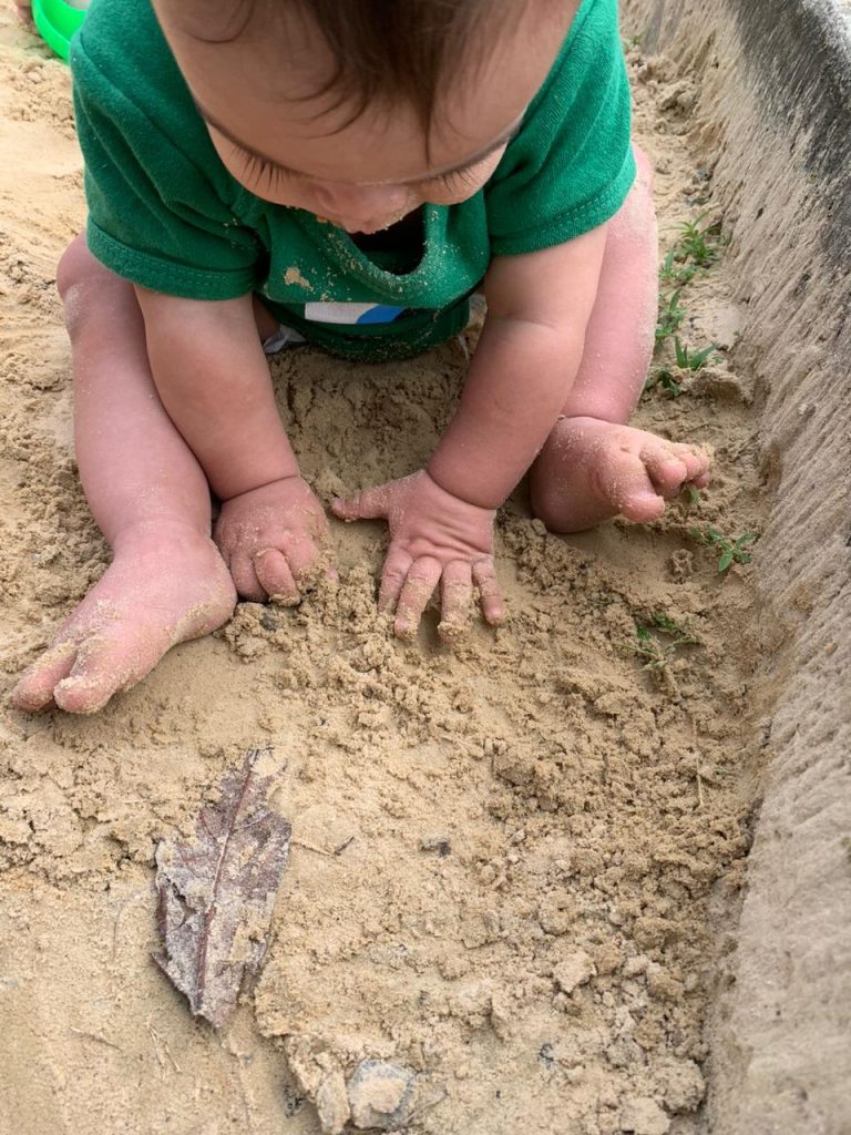 Bebê brincando no tanque de areia