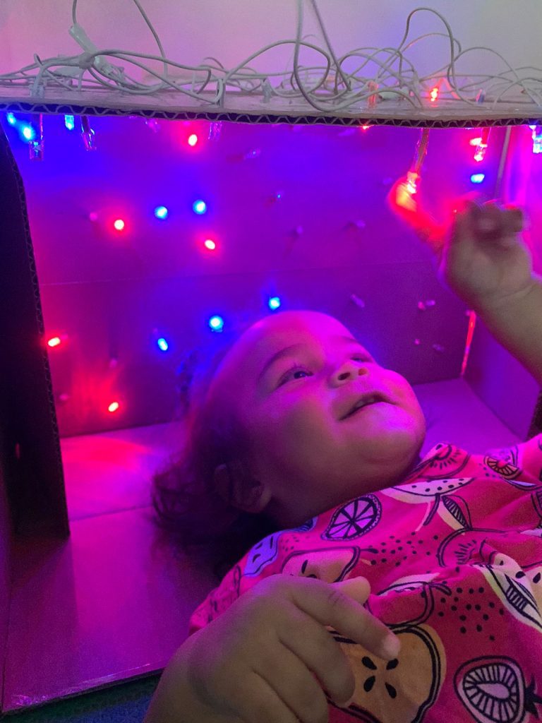 Bebê brincando com luzes coloridas